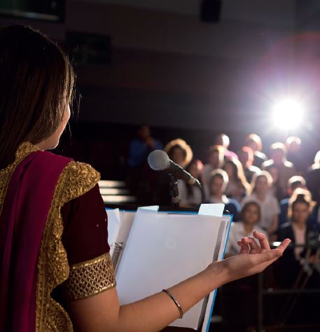 Woman behind lectern giving presentation - speech and performance skills