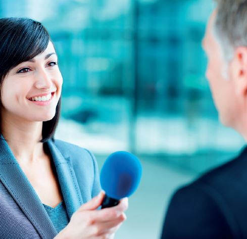 Female interviewer holding microphone - Voice and Communications skills